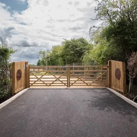 Timber five-bar gates across a tarmac drive